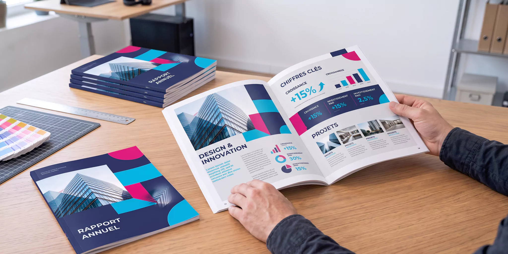 Rapport annuel ouvert, exemplaire fermé et pile d’exemplaires imprimés après correction du fichier