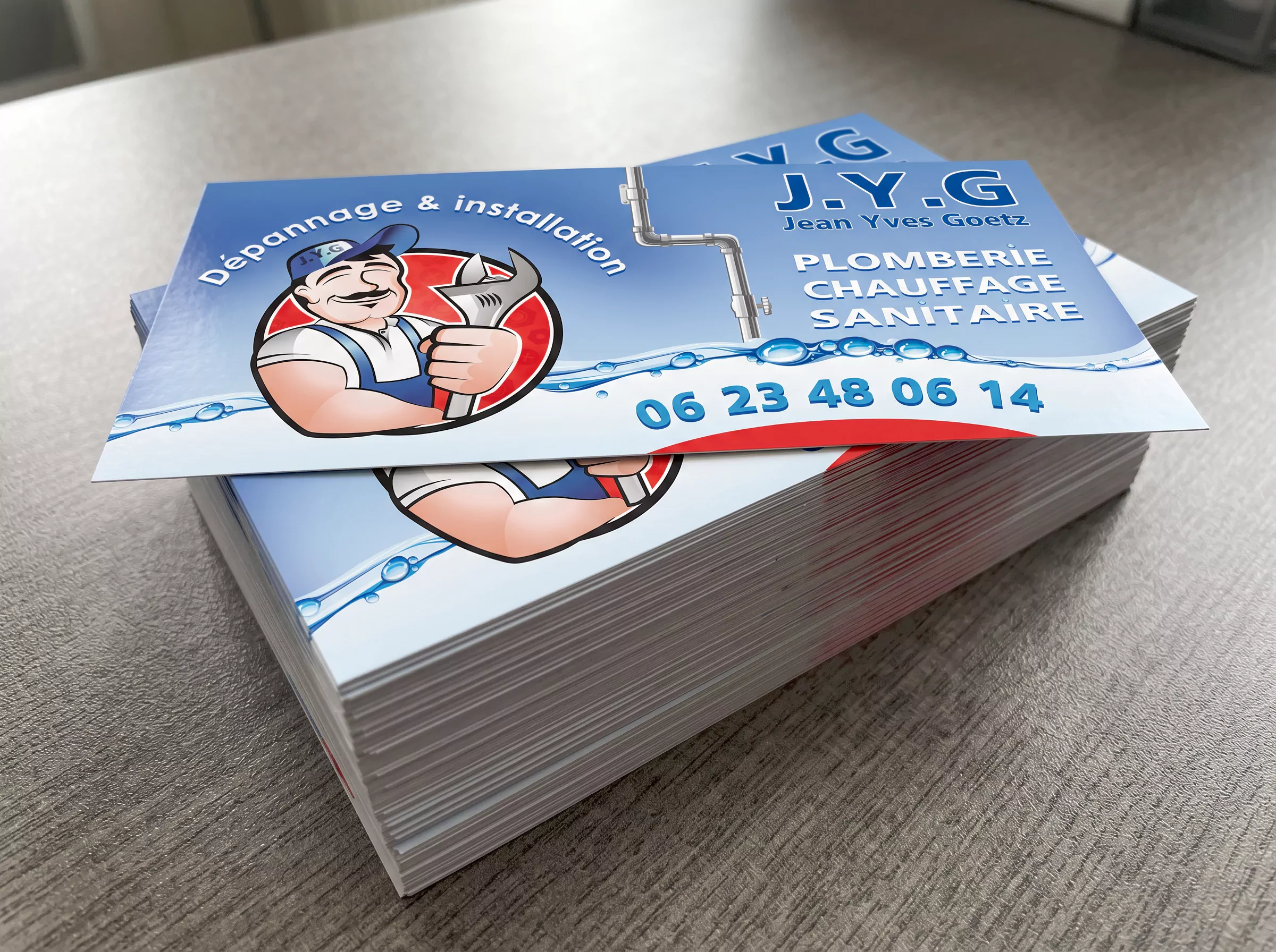 Pile de flyers J.Y.G pour une activité de plomberie, chauffage et sanitaire, imprimés au format 10 × 21 cm sur papier couché brillant.