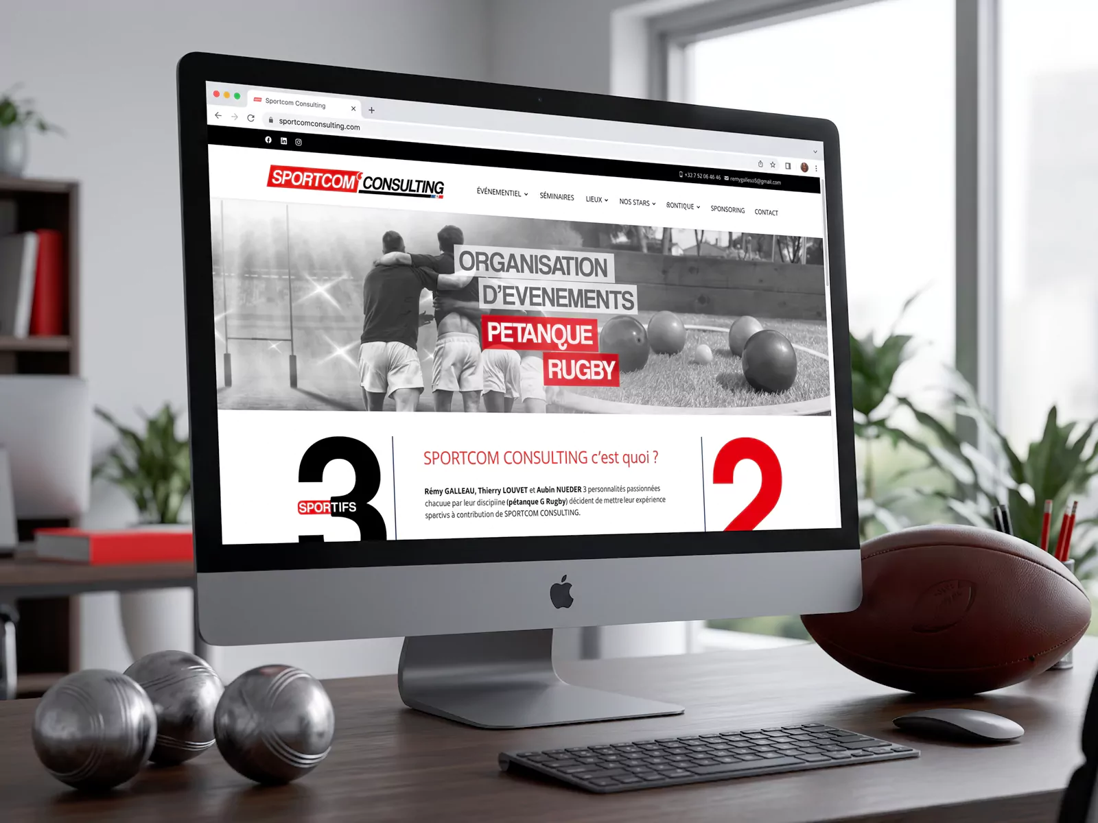 Page d’accueil du site Sportcom Consulting sur un écran, avec un ballon de rugby et des boules de pétanque.